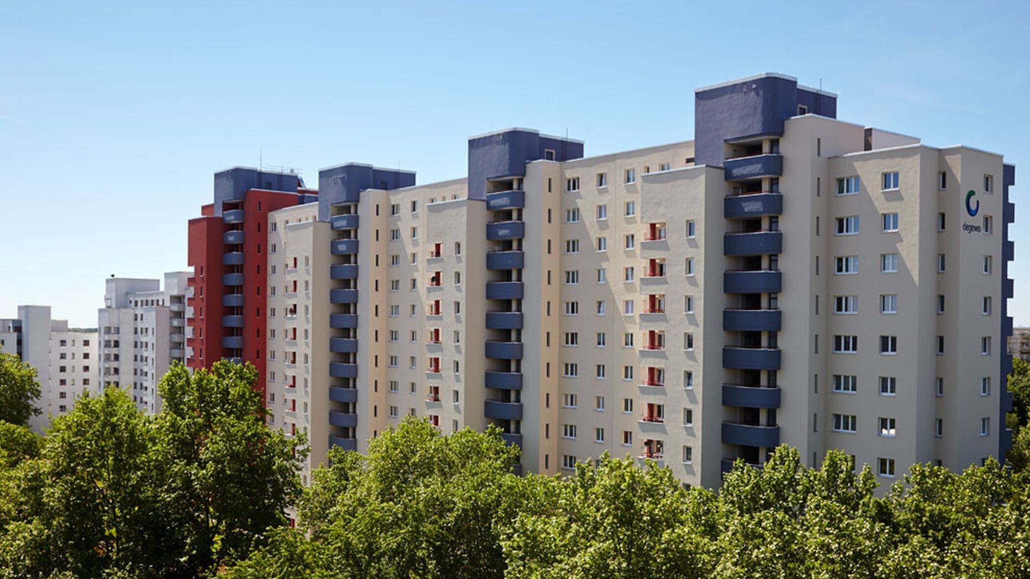 Außenansicht degewo-Ankauf Waldsassener Straße 11 und 16 bis 22 Lichtenfelder Ring 81 bis 89: Blick aus großer Entfernung mit Baumreihe im Vordergrund.