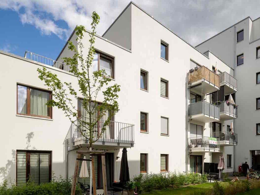 Außenansicht degewo-Neubau Glasower Straße 3 A mit neu gepflanztem Baum im Vordergrund.