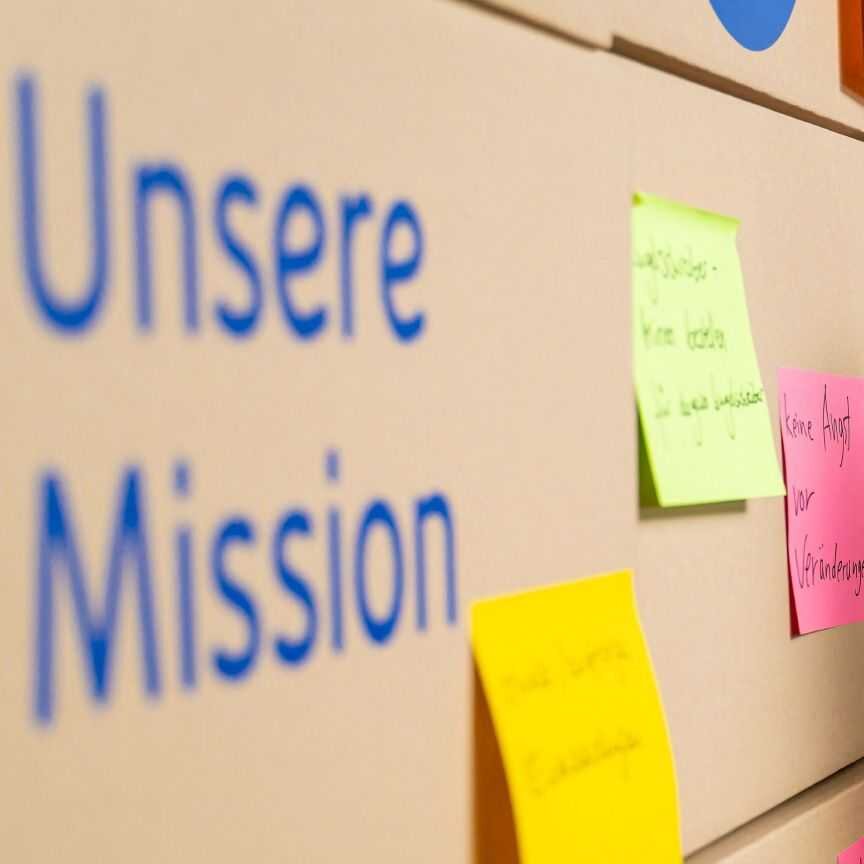 Pinnwand mit der Aufschrift „Unsere Mission“ und bunten Haftnotizen