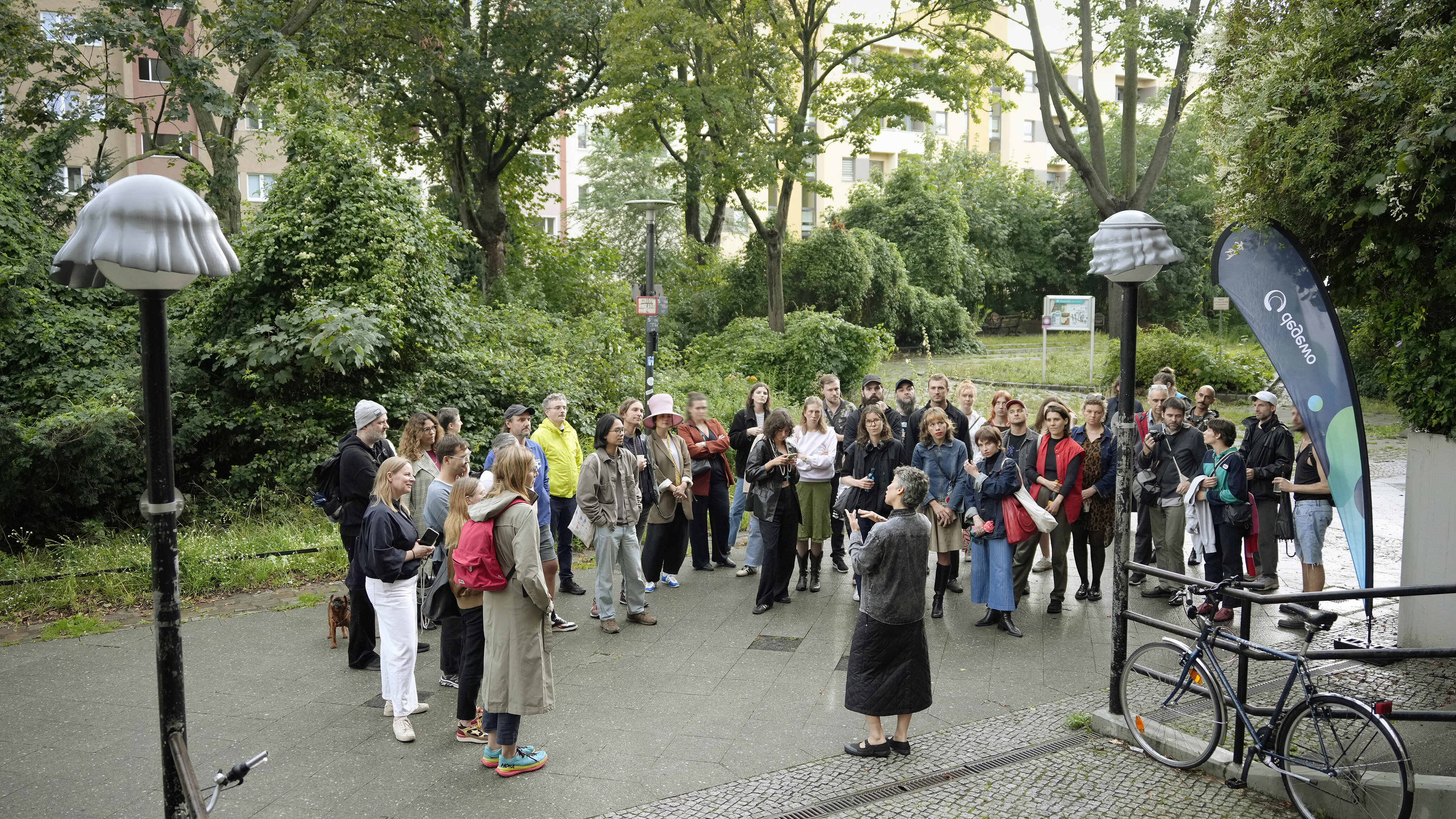 Gruppe von Menschen bei einer Führung im begrünten Wohnumfeld.
