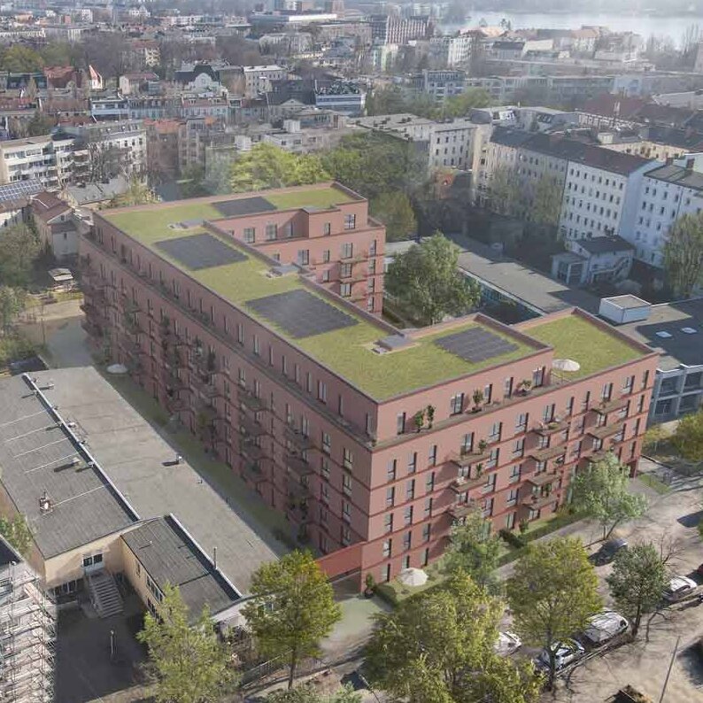 Luftperspektive eines sechsgeschossigen Neubaus mit roter Klinkerfassade und begrüntem Dach in innerstädtischer Lage. Balkone sind zur Hofseite ausgerichtet.