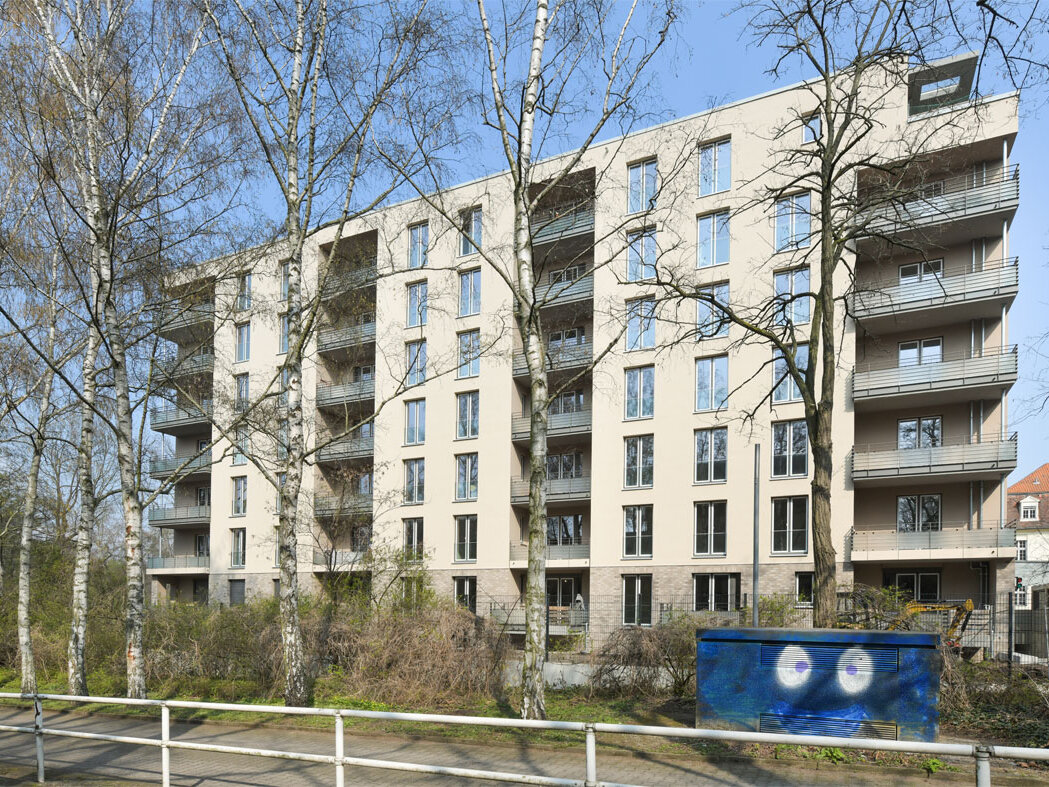 Außenansicht degewo-Neubau Pulsstraße 13 und 15 mit Schutzgeländer und Weg im Vordergrund.
