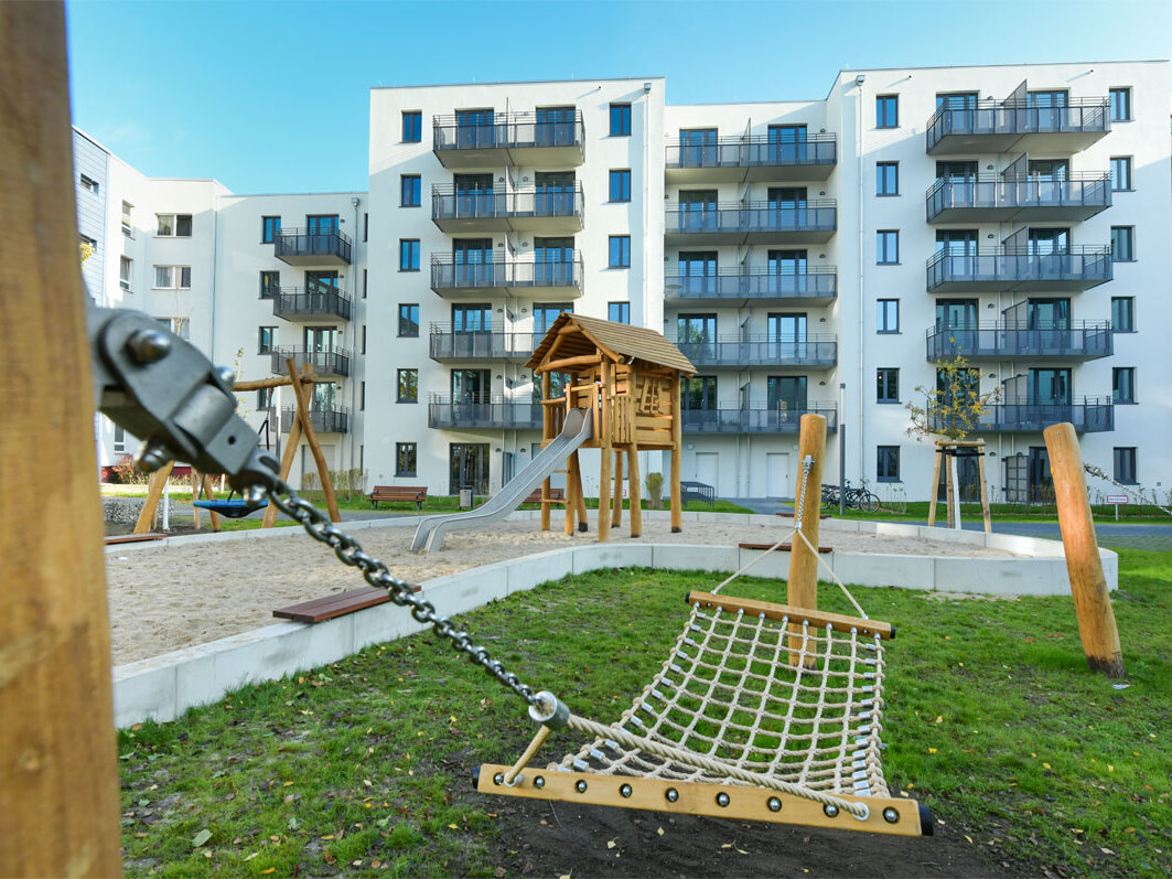 Außenansicht degewo-Neubau Mahlower Straße 2 bis 4 A mit Spielplatz im Vordergrund.