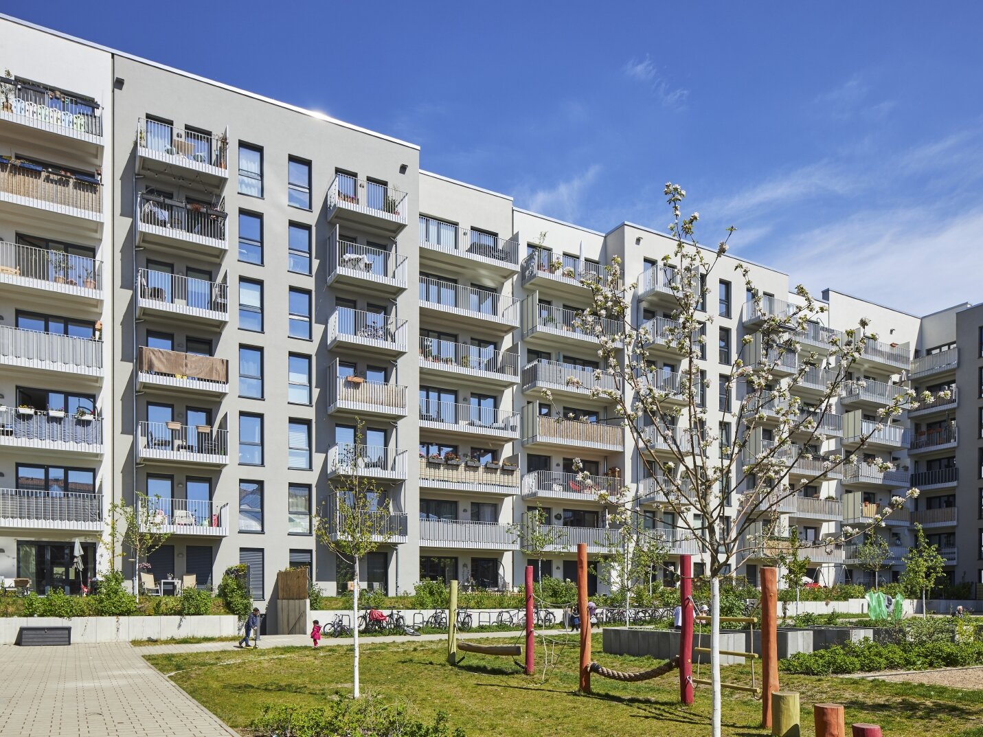 Außenansicht degewo-Neubau Usedomer Straße 25, 26 und 27: Hofseite mit Spielplatz im Vordergrund.