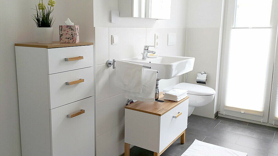 Lichtdurchflutetes Badezimmer mit weiß-braunen Möbeln