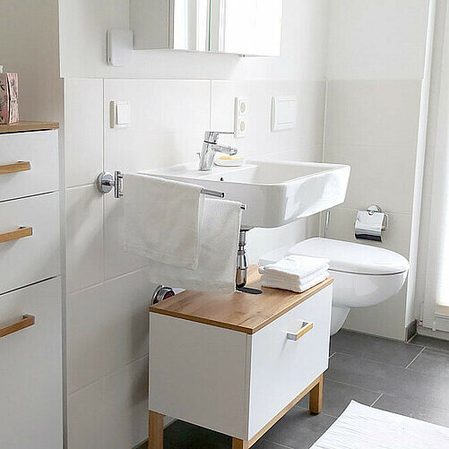 Lichtdurchflutetes Badezimmer mit weiß-braunen Möbeln