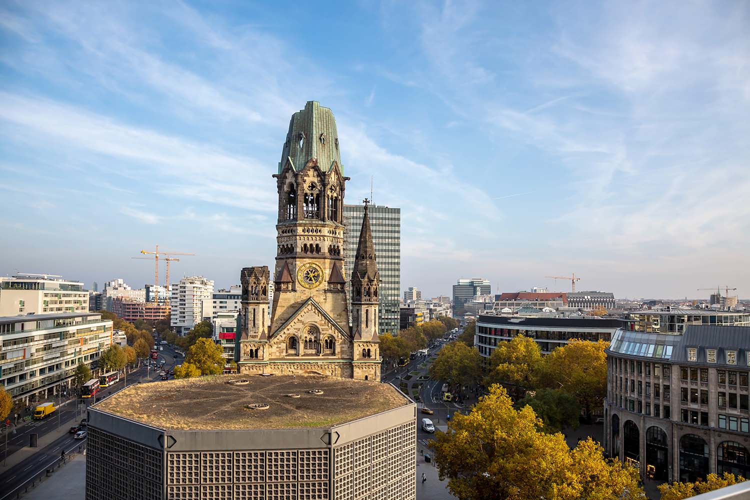 Kaiser-Wilhelm-Gedächtniskirche am Breitscheidplatz, umgeben von moderner Bebauung in Berlin-Charlottenburg.