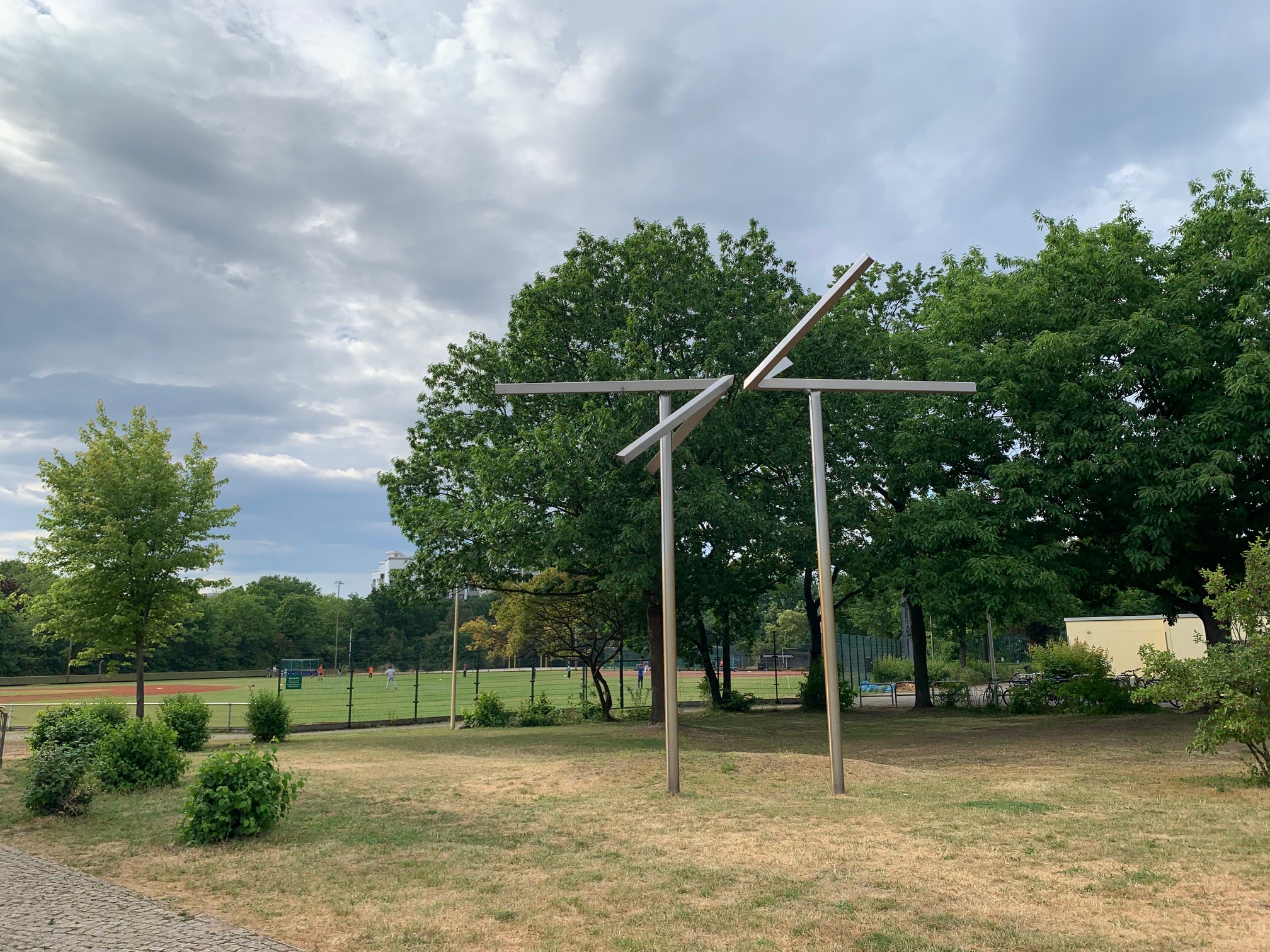 Ein Kunstobjekt aus Stahlrohren: Zwei senkrechte Rohre auf denen jeweils ein flügelartiger Aufbau aus Stahlrohren sitzt.