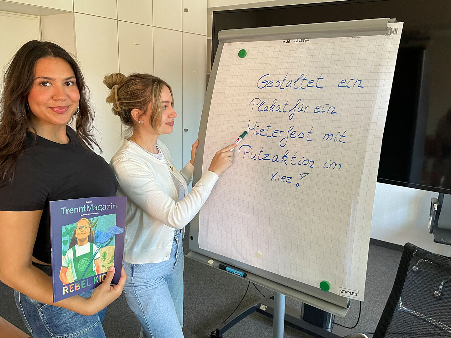 Azubis an einem Flipchart zum Thema Plakat gestalten