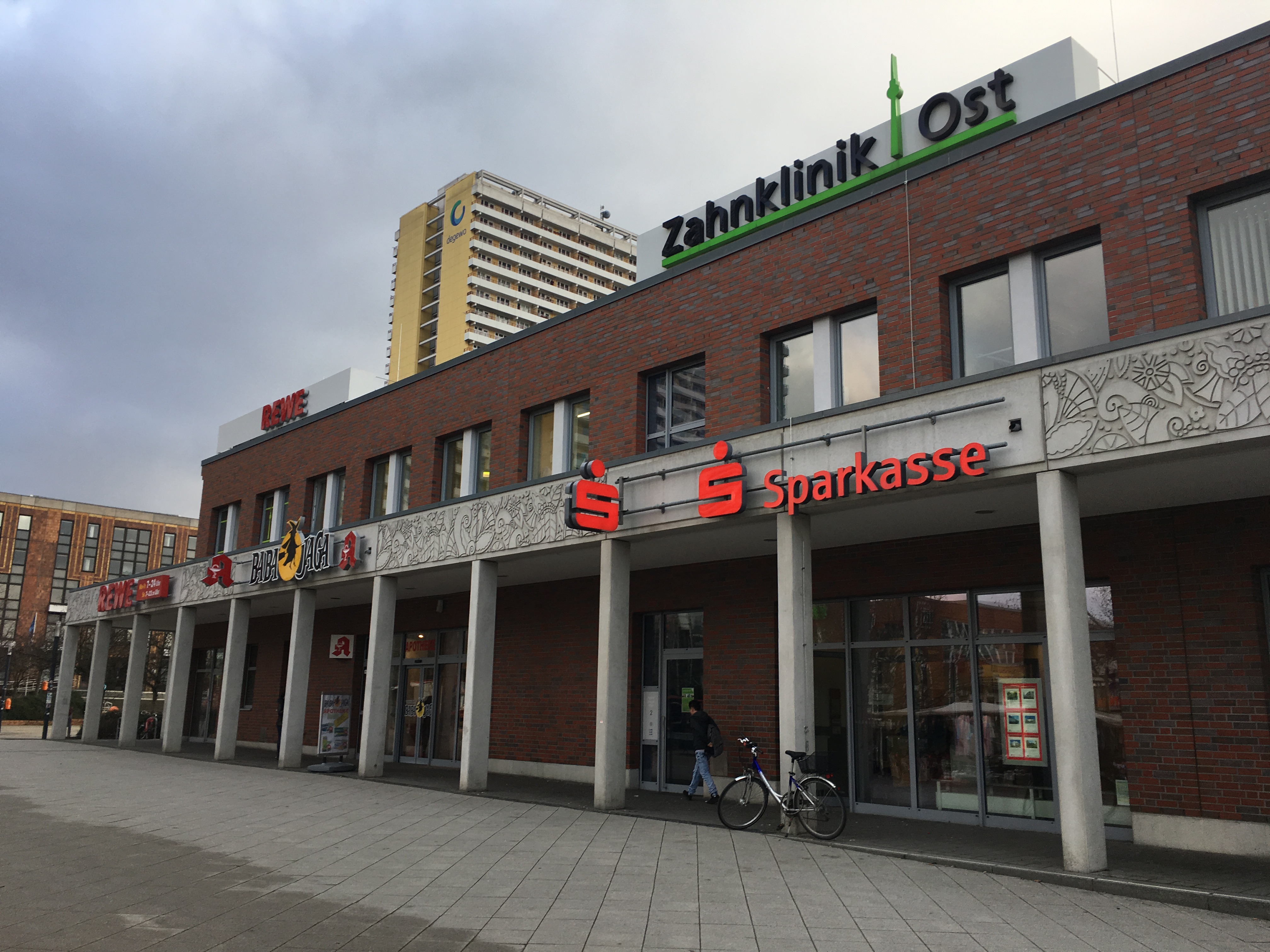 Ein Betonplatz mit Ständen links an der Seite, rechts ein Gebäude