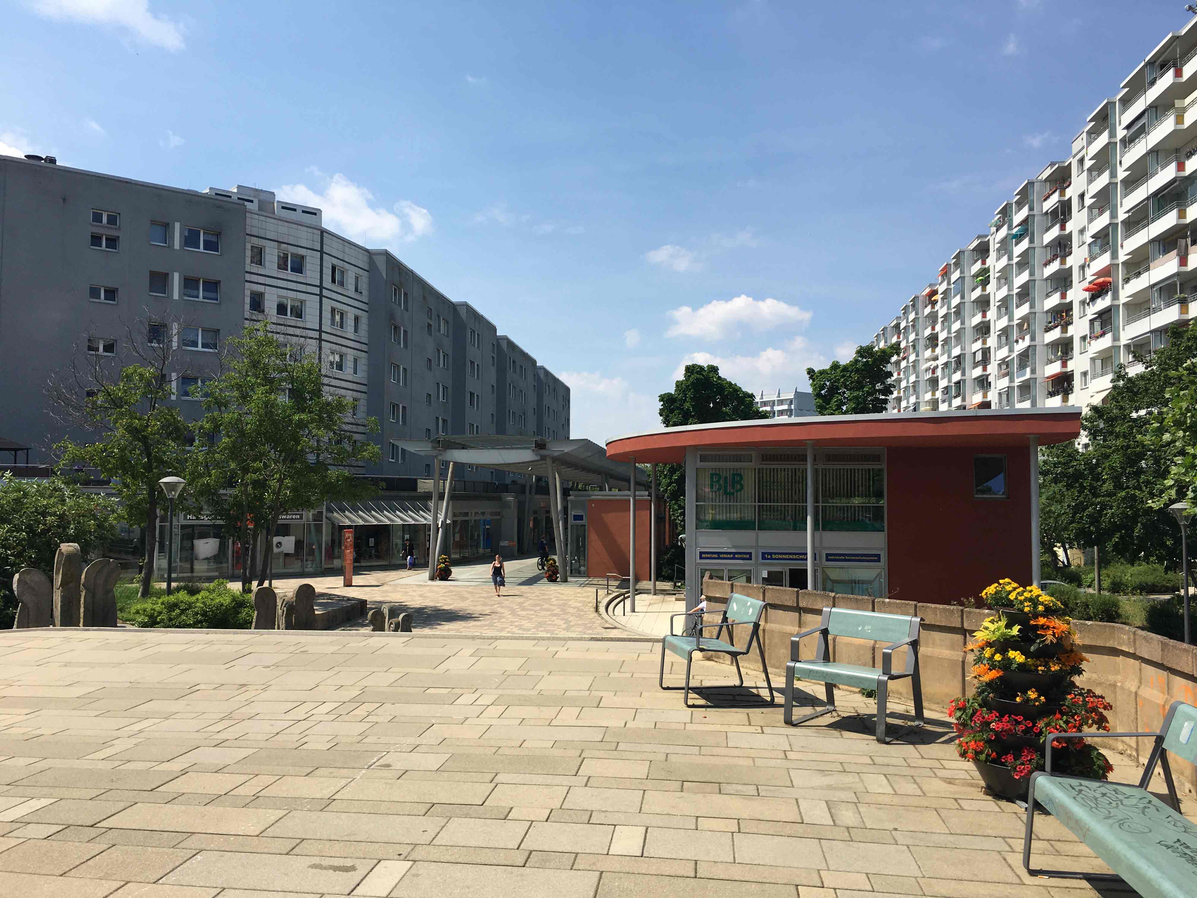 Blick auf einen Platz mit Geschäften zwischen Hochhäusern